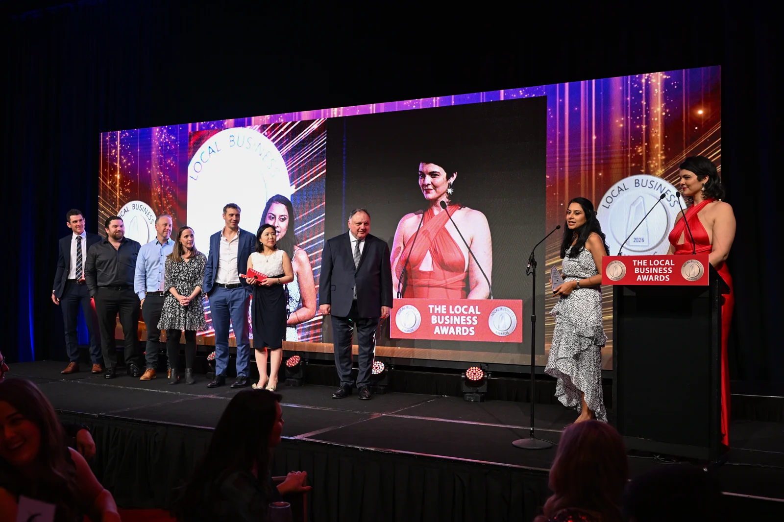 The Modia Health group during the award acceptance, with a member of the group speaking at the microphone.