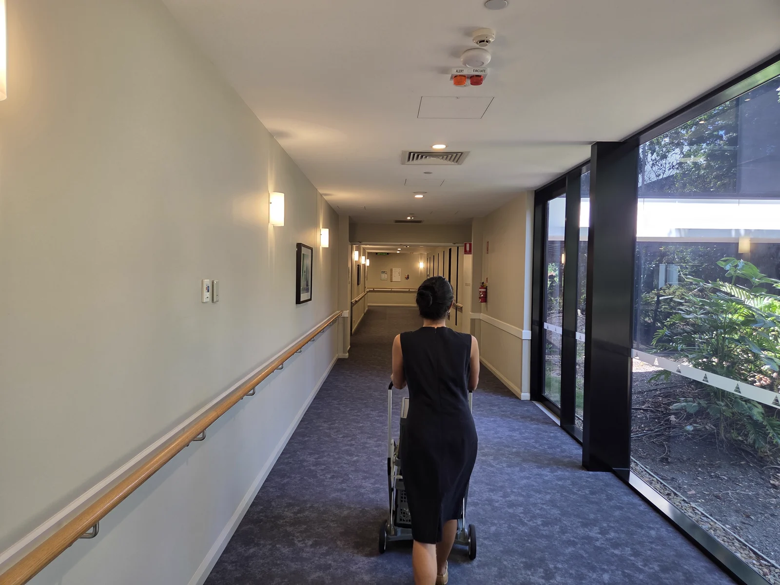A Modia clinician moving portable imaging equipment along a facility corridor